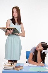 Image showing Schoolgirl listens to a boring teacher