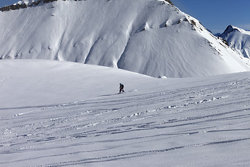 Image showing Snowboarder downhill on off piste slope with newly-fallen snow