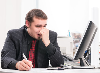 Image showing young businessman on workplace in office