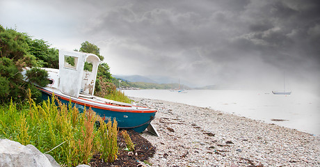 Image showing Small shipwreck at a loch with stone beach