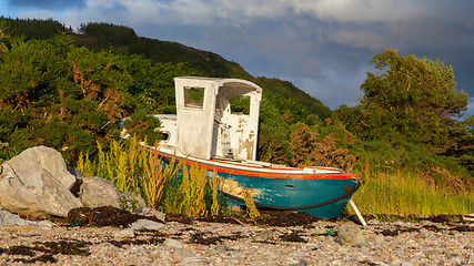 Image showing Small shipwreck at a loch with stone beach