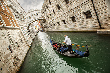 Image showing Gondola with gondolier and tourists on the canal in the Venice