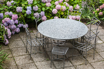 Image showing table and chairs in garden with color hydrangea