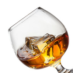 Image showing Splash of whiskey with ice in glass isolated on white background