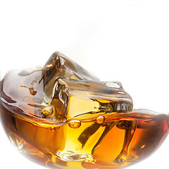 Image showing Splash of whiskey with ice in glass isolated on white background
