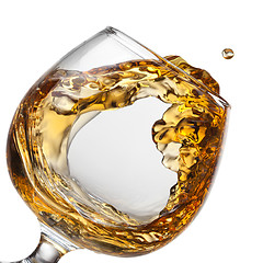 Image showing Splash of cognac in glass isolated