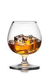 Image showing Splash of whiskey with ice in glass isolated on white