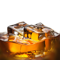 Image showing Splash of whiskey with ice in glass isolated on white