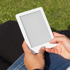 Image showing Woman reading ebook on the grass