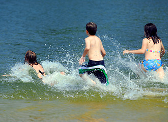 Image showing Children running into water