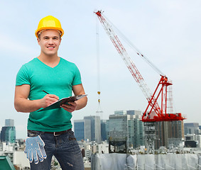 Image showing smiling man in helmet with clipboard