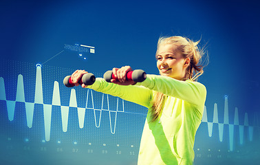 Image showing sporty woman with light dumbbells outdoors