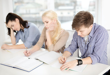 Image showing tired students with notebooks at school