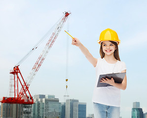 Image showing smiling little girl in hardhat with clipboard