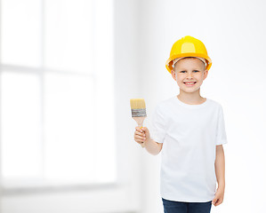 Image showing smiling little boy in helmet with paint brush