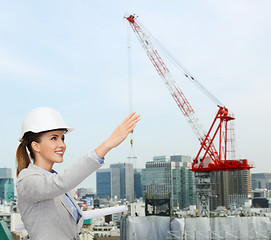 Image showing smiling architect in helmet with blueprint