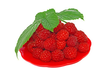 Image showing Ripe raspberries decorated with green leaf in a small platter   