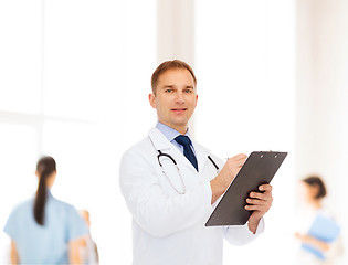 Image showing smiling male doctor with clipboard and stethoscope