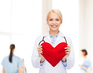 Image showing smiling female doctor with heart and stethoscope