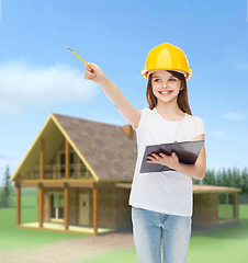 Image showing smiling little girl in hardhat with clipboard