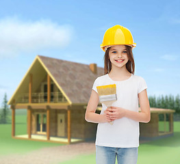 Image showing smiling little girl in helmet with paint brush