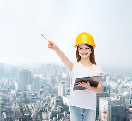 Image showing smiling little girl in hardhat with clipboard