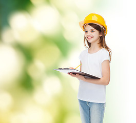 Image showing smiling little girl in hardhat with clipboard