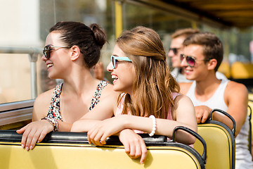 Image showing group of smiling friends traveling by tour bus