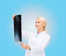 Image showing smiling female doctor looking at x-ray