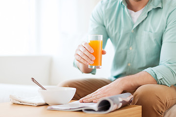 Image showing close up of man with magazine drinking juice