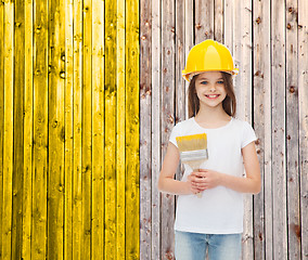 Image showing smiling little girl in helmet with paint brush