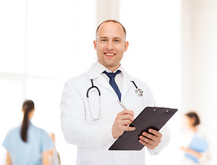 Image showing smiling male doctor with clipboard and stethoscope