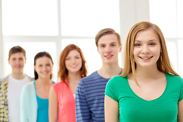 Image showing smiling students with teenage girl in front