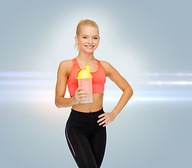 Image showing smiling sporty woman with protein shake bottle