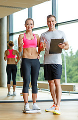 Image showing smiling man and woman with scales in gym