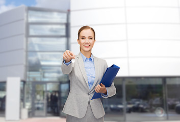 Image showing smiling businesswoman with folder and keys