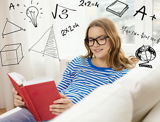 Image showing smiling teenage girl reading book on couch