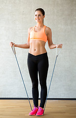 Image showing smiling woman with expander in gym