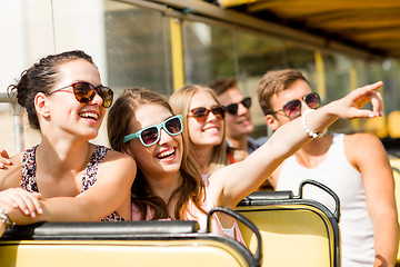 Image showing group of smiling friends traveling by tour bus