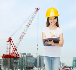 Image showing smiling little girl in hardhat with clipboard