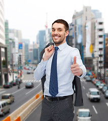 Image showing smiling young businessman showing thumbs up