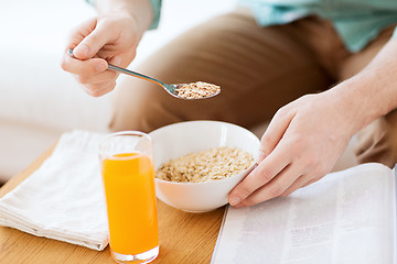 Image showing close up of man with magazine eating breakfast