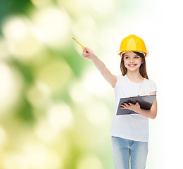 Image showing smiling little girl in hardhat with clipboard