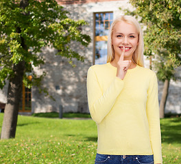 Image showing young woman with finger on her lip