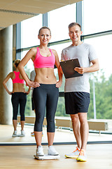 Image showing smiling man and woman with scales in gym