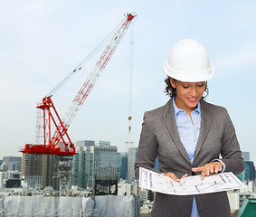 Image showing businesswoman in white helmet with blueprint