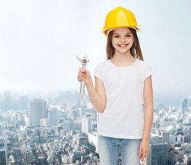 Image showing smiling little girl in hardhat with wrench