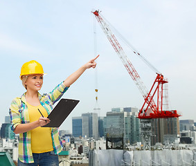 Image showing smiling woman in helmet with clipboard