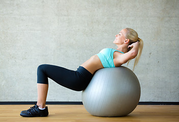 Image showing smiling woman with exercise ball in gym