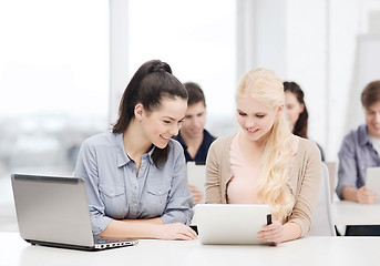 Image showing two smiling students with laptop and tablet pc